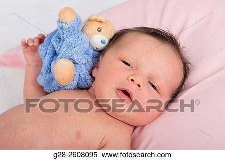 Stock Photography - Baby 2 weeks old with soft toy. Fotosearch