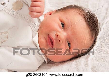 Picture - Baby Boy 2 weeks old, awake and smiling in white. Fotosearch
