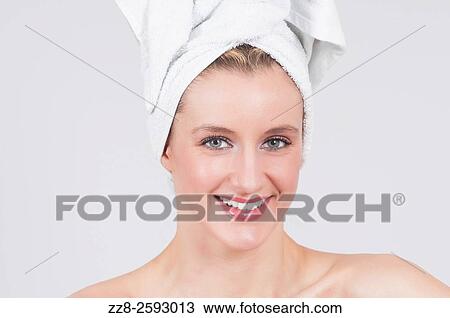 Stock Image - Beautiful woman after shower with white towel wrapped on her head.. Fotosearch
