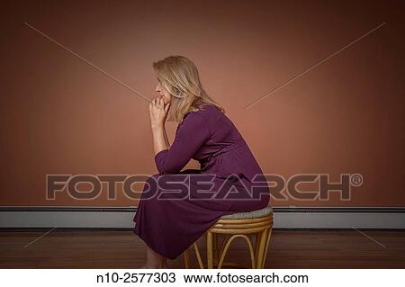 Blond woman sitting on a stool. View Large Photo Image Stock Image - Blond woman sitting on a stool.. Fotosearch