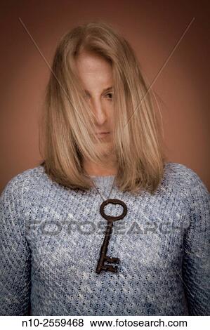 Blond woman with an old key hanging around her neck. View Large Photo Image Stock Photo - Blond woman with an old key hanging around her neck.. Fotosearch