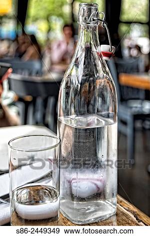 Bottle and Glass of Water on a New York City Restaurant Table. View Large Photo Image Stock Photo - Bottle and Glass of Water on a New York City Restaurant Table.. Fotosearch