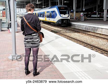 Breda, Netherlands. Female commuter waiting for her connecting train on the platform of Breda Central Railway Station. View Large Photo Image Stock Photo - Breda, Netherlands. Female commuter waiting for her connecting train on the platform of Breda Central Railway Station.. Fotosearch