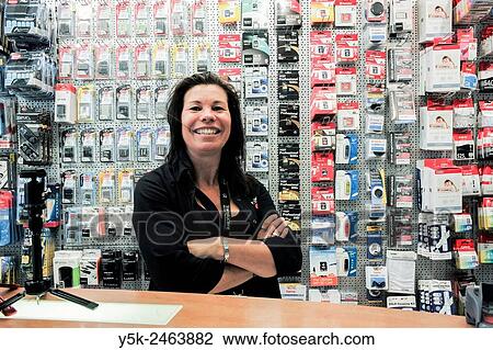 Breda, Netherlands. Female employee of a photo store standing behind the shops counter. View Large Photo Image Stock Image - Breda, Netherlands. Female employee of a photo store standing behind the shops counter.. Fotosearch