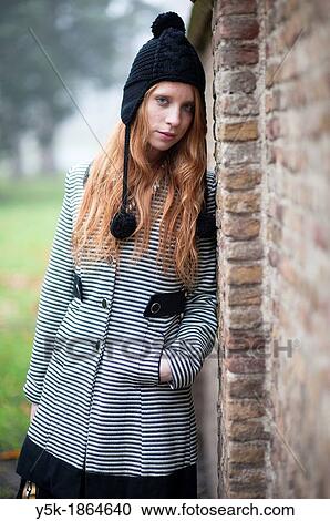 Breda, Netherlands. Young, fashionable and redheaded woman in a city-park, leaning against a wall. View Large Photo Image Stock Image - Breda, Netherlands. Young, fashionable and redheaded woman in a city-park, leaning against a wall.. Fotosearch