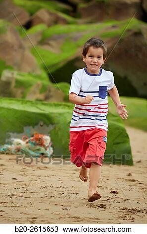Stock Image - Child playing on the beach. Getaria. Gipuzkoa. Basque Country. Spain. Fotosearch