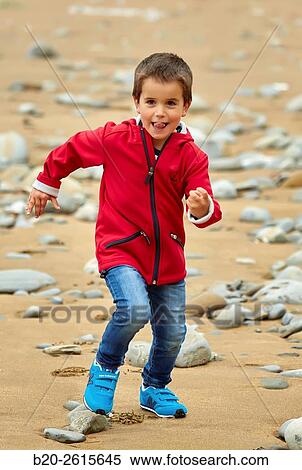 Stock Photography - Child playing on the beach. Getaria. Gipuzkoa. Basque Country. Spain. Fotosearch
