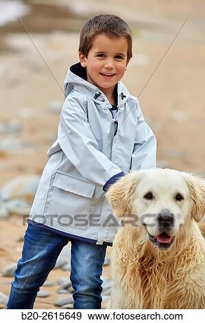 Stock Photo - Child with dog playing on the beach. Getaria. Gipuzkoa. Basque Country. Spain. Fotosearch
