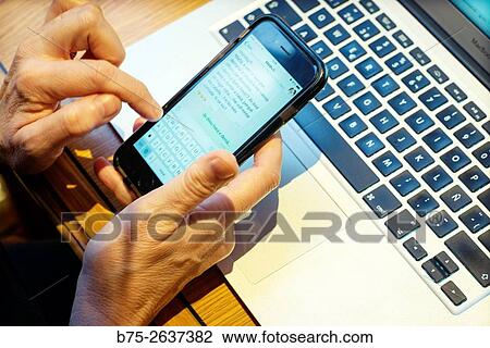 close-up of a female hands manipulating a mobile phone with a keyboard of a laptop in the background. View Large Photo Image Stock Image - close-up of a female hands manipulating a mobile phone with a keyboard of a laptop in the background.. Fotosearch
