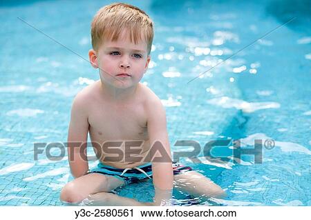 Close up of a young male child sitting in a swimming pool looking bored. View Large Photo Image Stock Image - Close up of a young male child sitting in a swimming pool looking bored.. Fotosearch