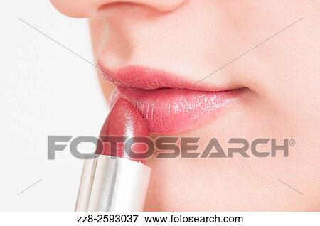 Close up of a young woman applying make up lipstick. View Large Photo Image Stock Photo - Close up of a young woman applying make up lipstick.. Fotosearch