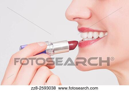 Close up of a young woman applying make up lipstick. View Large Photo Image Stock Photo - Close up of a young woman applying make up lipstick.. Fotosearch