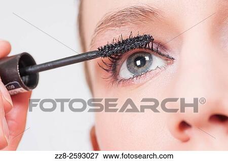 Close up of a young woman applying mascara to eyelashes. View Large Photo Image Stock Photo - Close up of a young woman applying mascara to eyelashes.. Fotosearch