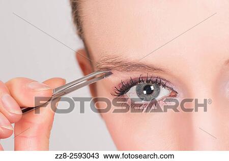 Close up of a young woman plucking her eyebrows. View Large Photo Image Stock Image - Close up of a young woman plucking her eyebrows.. Fotosearch