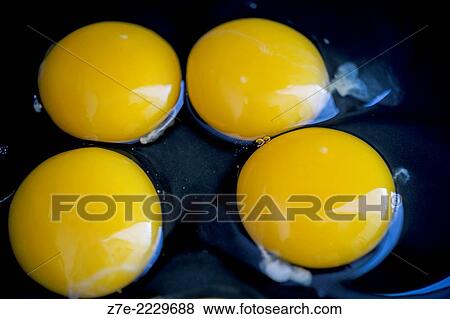 Stock Photo - Close-up of four cracked eggs.. Fotosearch