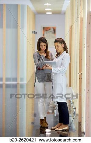 Corridor. Doctor attending to patient medical consultation. Tablet. Office. View Large Photo Image Stock Image - Corridor. Doctor attending to patient medical consultation. Tablet. Office.. Fotosearch