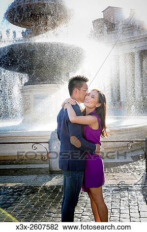 Couple getting wet next to a water fountain in Saint Peters square. Vatican, Rome, Italy. View Large Photo Image Stock Image - Couple getting wet next to a water fountain in Saint Peters square. Vatican, Rome, Italy.. Fotosearch