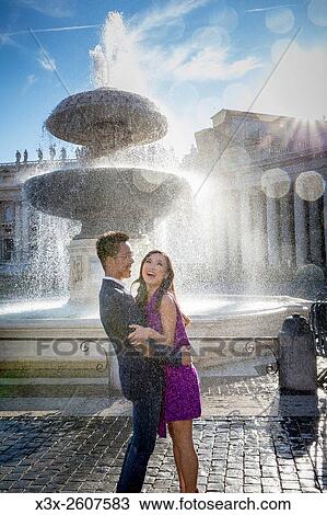 Couple getting wet next to a water fountain in Saint Peters square. Vatican, Rome, Italy. View Large Photo Image Stock Image - Couple getting wet next to a water fountain in Saint Peters square. Vatican, Rome, Italy.. Fotosearch