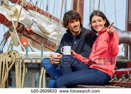 Stock Image - Couple outside a sailboat, galleon. Masts. Basque Country. Spain. Fotosearch