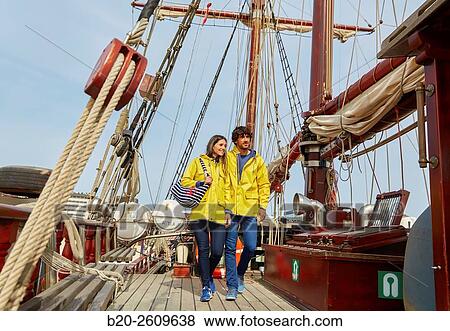 Stock Photo - Couple outside a sailboat, galleon. Masts. Basque Country. Spain. Fotosearch