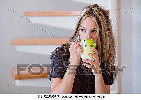 Cute girl drinking coffee while sitting on stairs View Large Photo Image Stock Image - Cute girl drinking coffee while sitting on stairs. Fotosearch