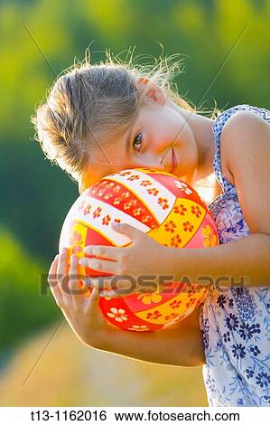 Cute girl is hiding behind a ball View Large Photo Image Stock Photograph - Cute girl is hiding behind a ball. Fotosearch