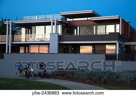 Cyclists passing a multi-million dollar luxury seaside home on Brighton's? Golden Mile?, Melbourne, Australia. View Large Photo Image Stock Image - Cyclists passing a multi-million dollar luxury seaside home on Brighton's? Golden Mile?, Melbourne, Australia.. Fotosearch