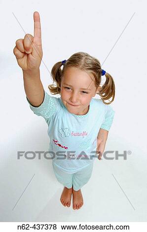 Determined Little girl top view shows the index finger lifting the arm upwards View Large Photo Image Stock Photo - Determined Little girl top view shows the index finger lifting the arm upwards. Fotosearch