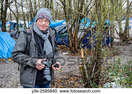 Dunkerque, France. Male photographer working in a camp for illegal migrants, bound for the UK. View Large Photo Image Stock Image - Dunkerque, France. Male photographer working in a camp for illegal migrants, bound for the UK.. Fotosearch