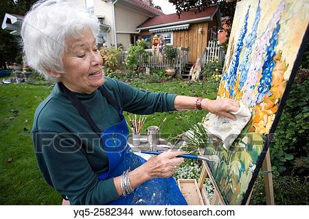 Picture - elderly artist painting in garden.. Fotosearch