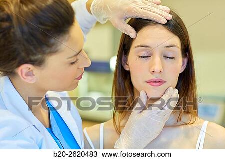 Stock Image - Facelift. Blepharoplasty. Surgery that aims to rejuvenate the look. It is to remove excess skin and bags of both eyelids and periocular tissue remodeling. Plastic surgery. Doctor attending to patient medical consultation.. Fotosearch