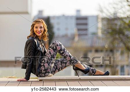 Stock Image - Fanciful young lady sitting reclining on hand. Fotosearch