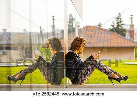 Fanciful young lady sitting writing sms message View Large Photo Image Stock Photography - Fanciful young lady sitting writing sms message. Fotosearch