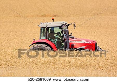 Stock Photo - Farm tractor. Agricultural machinery on field of wheat ½Learza½ estate Near Estella, Navarre, Spain. Fotosearch