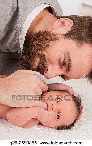 Father with beard trying to comfort his 2 weeks old baby boy by putting his little finger in his mouth as a dummy pacifier View Large Photo Image Stock Photography - Father with beard trying to comfort his 2 weeks old baby boy by putting his little finger in his mouth as a dummy pacifier. Fotosearch