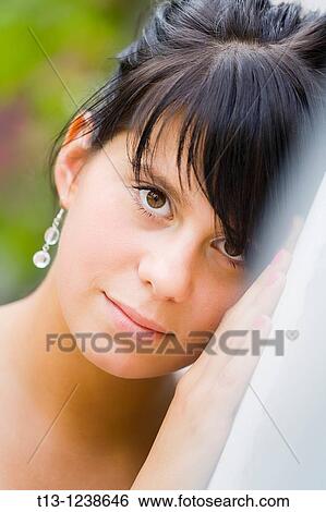 Stock Photograph - Female portrait inclined on the wall. Fotosearch