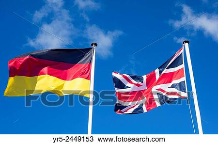 Stock Image - Flags of Germany and United Kingdom against blue sky.. Fotosearch