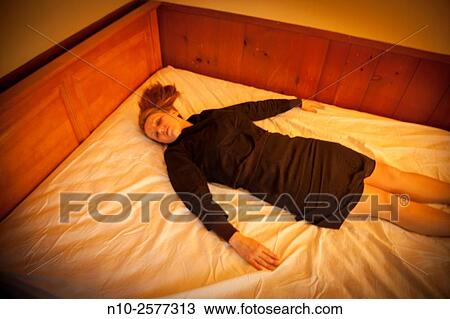Forty year old woman lying on her bed. View Large Photo Image Stock Image - Forty year old woman lying on her bed.. Fotosearch