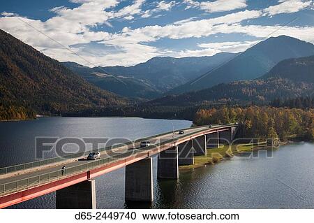 Stock Image - Germany, Bavaria, Fall, Fallerklamm Bridge over the Sylvenstein Lake, elevated view, fall.. Fotosearch