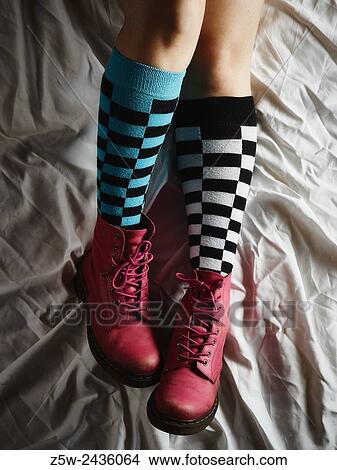 Picture - Girl lying on the bed and she wearing the socks and the pink shoes.. Fotosearch