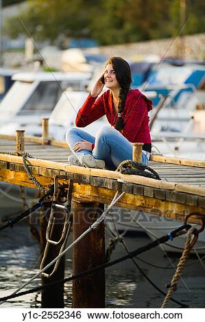 Girl next-door talking on cellphone View Large Photo Image Stock Photograph - Girl next-door talking on cellphone. Fotosearch
