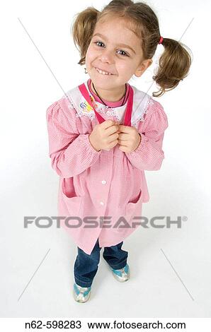 Girl top view with pigtails holds hands with straps of her backpack, she wearing a pink apron to the kindergarten View Large Photo Image Stock Image - Girl top view with pigtails holds hands with straps of her backpack, she wearing a pink apron to the kindergarten. Fotosearch