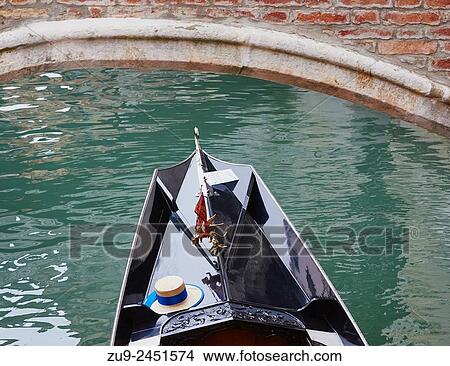 Gondola passing under a bridge with the Venetian flag and straw hat of the gondolier, Venice, Veneto, Italy, Europe. View Large Photo Image Picture - Gondola passing under a bridge with the Venetian flag and straw hat of the gondolier, Venice, Veneto, Italy, Europe.. Fotosearch