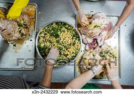 Stock Photo - Hands of people stuffing hams in St Mary's County Maryland, USA.. Fotosearch