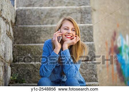 Stock Photograph - Happy teenager with cellphone enthusiastic. Fotosearch