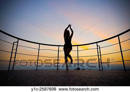Happy young woman silhouetting against sunset sky. View Large Photo Image Stock Photo - Happy young woman silhouetting against sunset sky.. Fotosearch