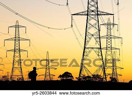 Hiker under electricity pylons at sunrise in Cowpen Woodland Park near Billingham, north east England, United Kingdom. View Large Photo Image Picture - Hiker under electricity pylons at sunrise in Cowpen Woodland Park near Billingham, north east England, United Kingdom.. Fotosearch