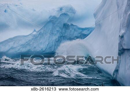 Stock Image - Huge swell breaking on tabular iceberg broken off from B-17A Iceberg near Cooper Bay, South Georgia.. Fotosearch