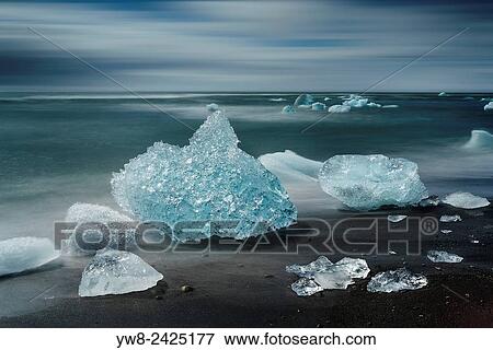 Stock Photo - Ice formations on black sand beach. Ice comes from the Breidamerkurjokull Glacier, Vatnajokull Ice Cap, Iceland.. Fotosearch