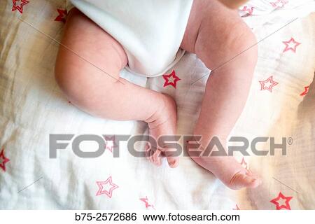 Stock Photograph - Legs of newborn baby in his crib. Fotosearch